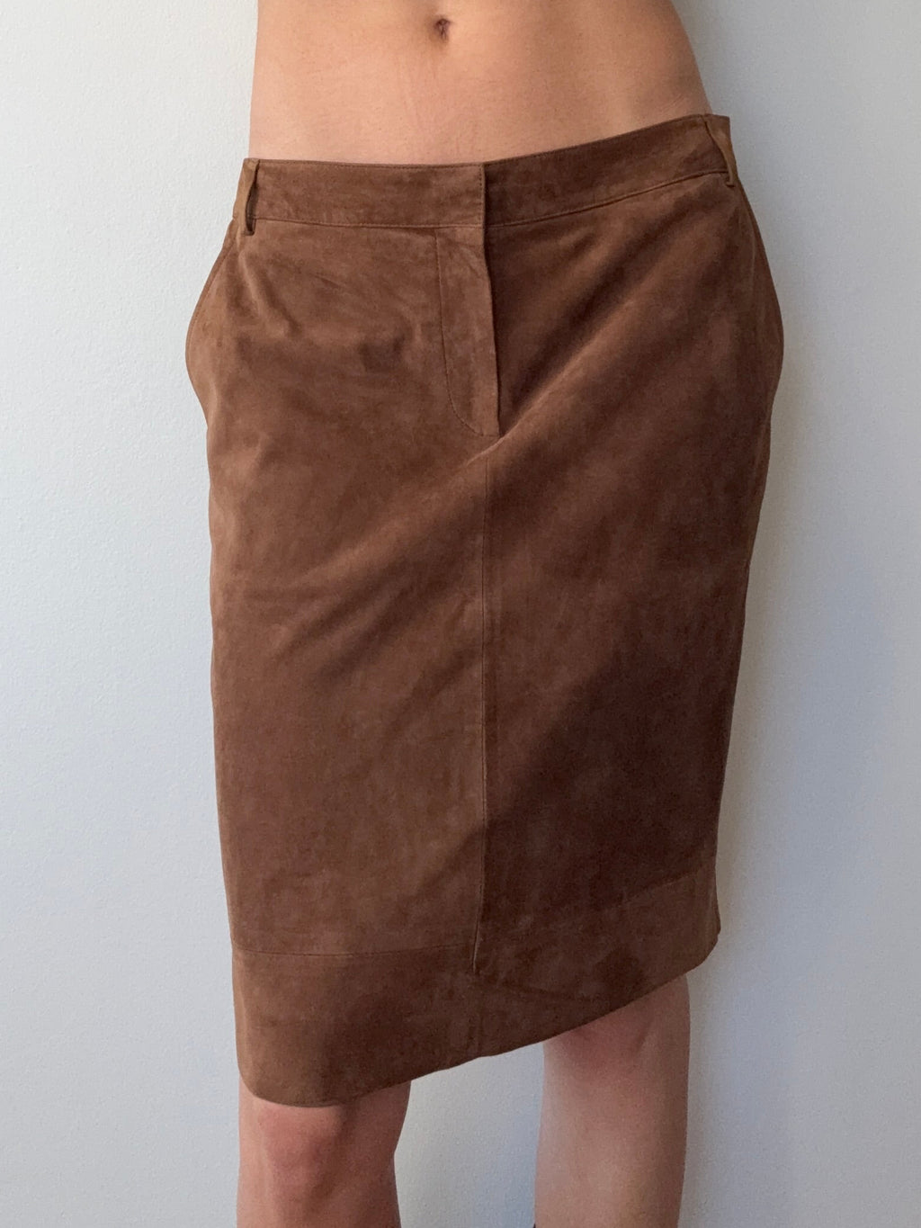 Brown shorts being worn by a person on a white background