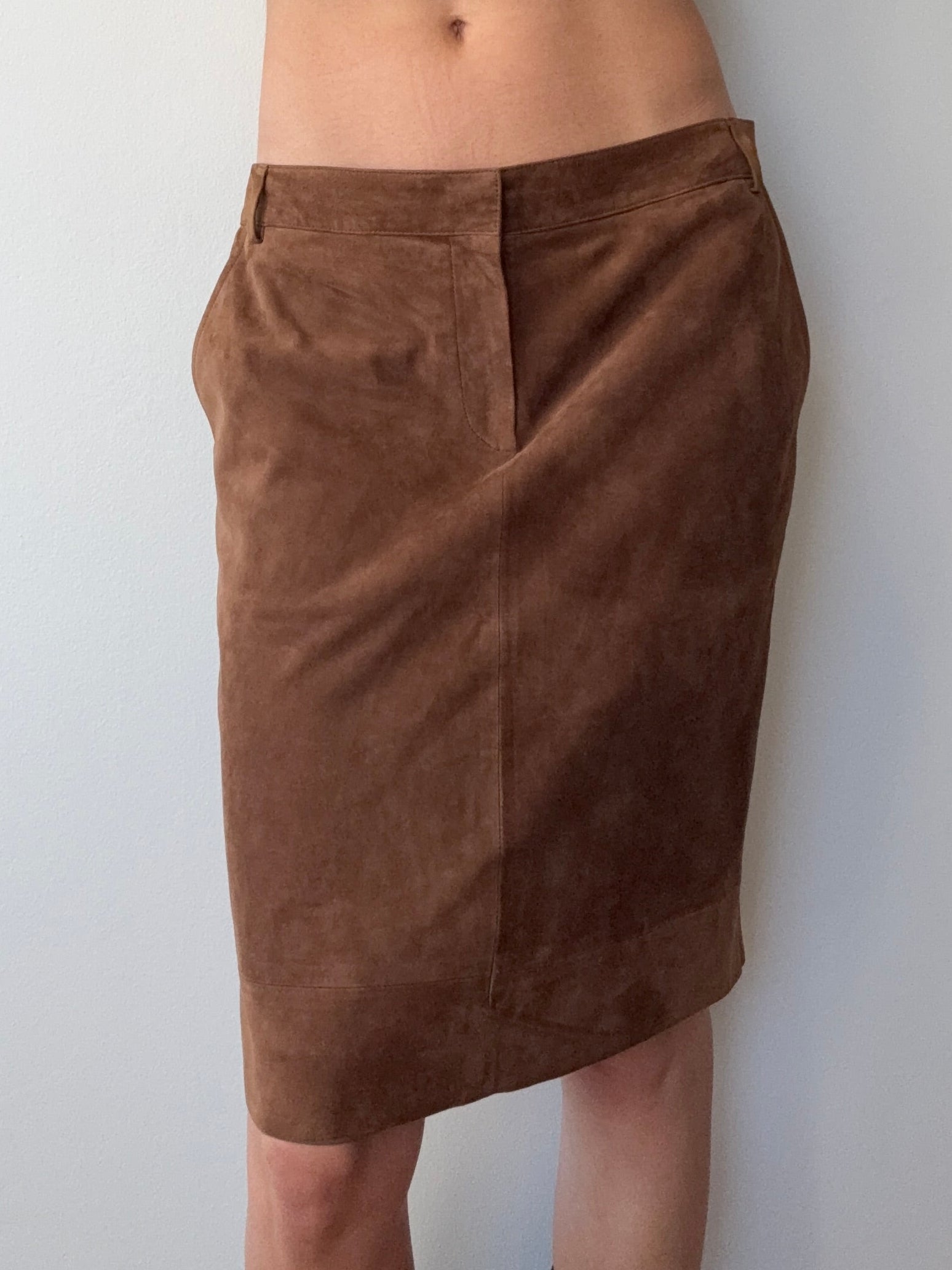 Brown shorts being worn by a person on a white background
