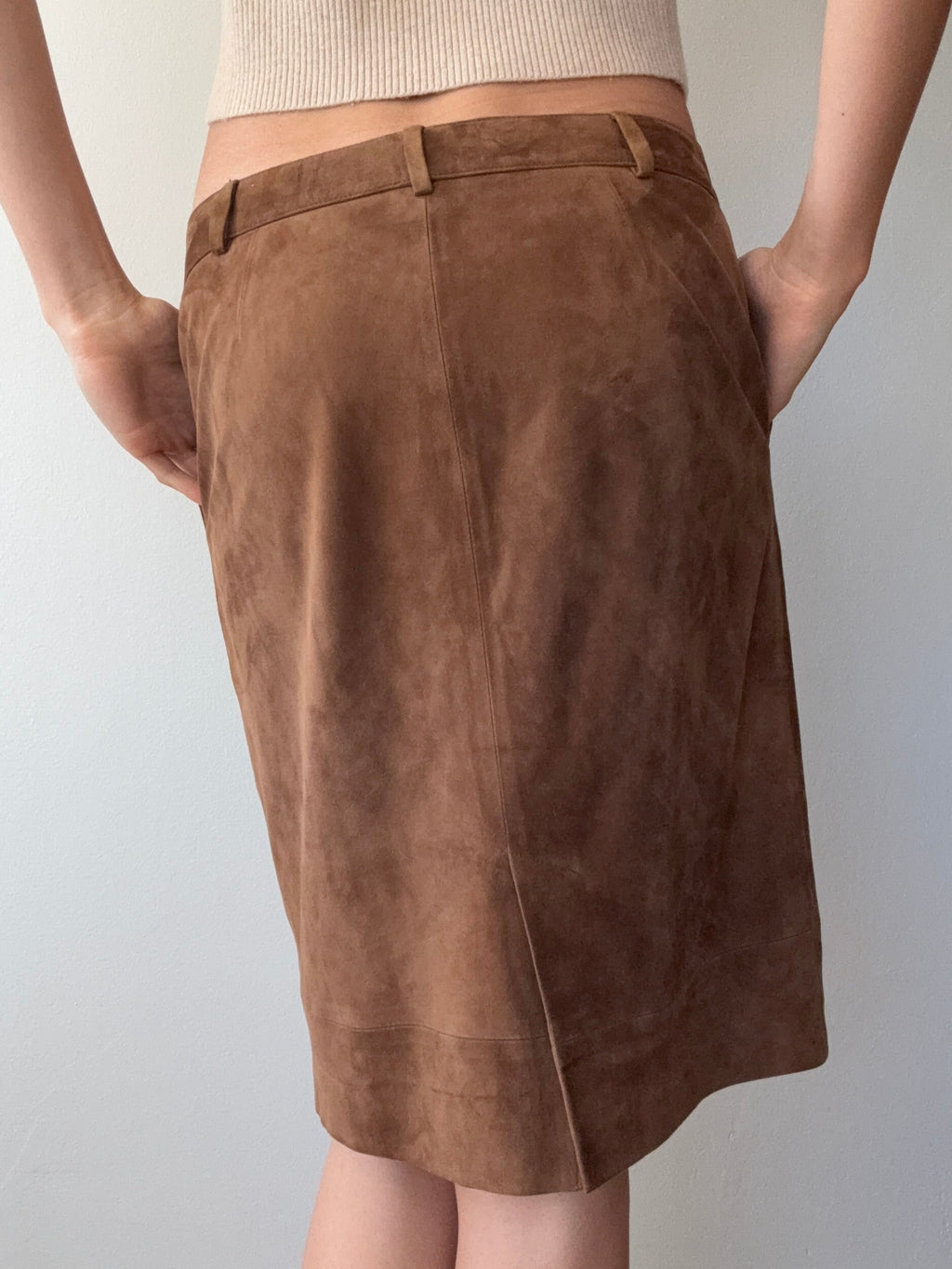Brown suede skirt held up against a plain background