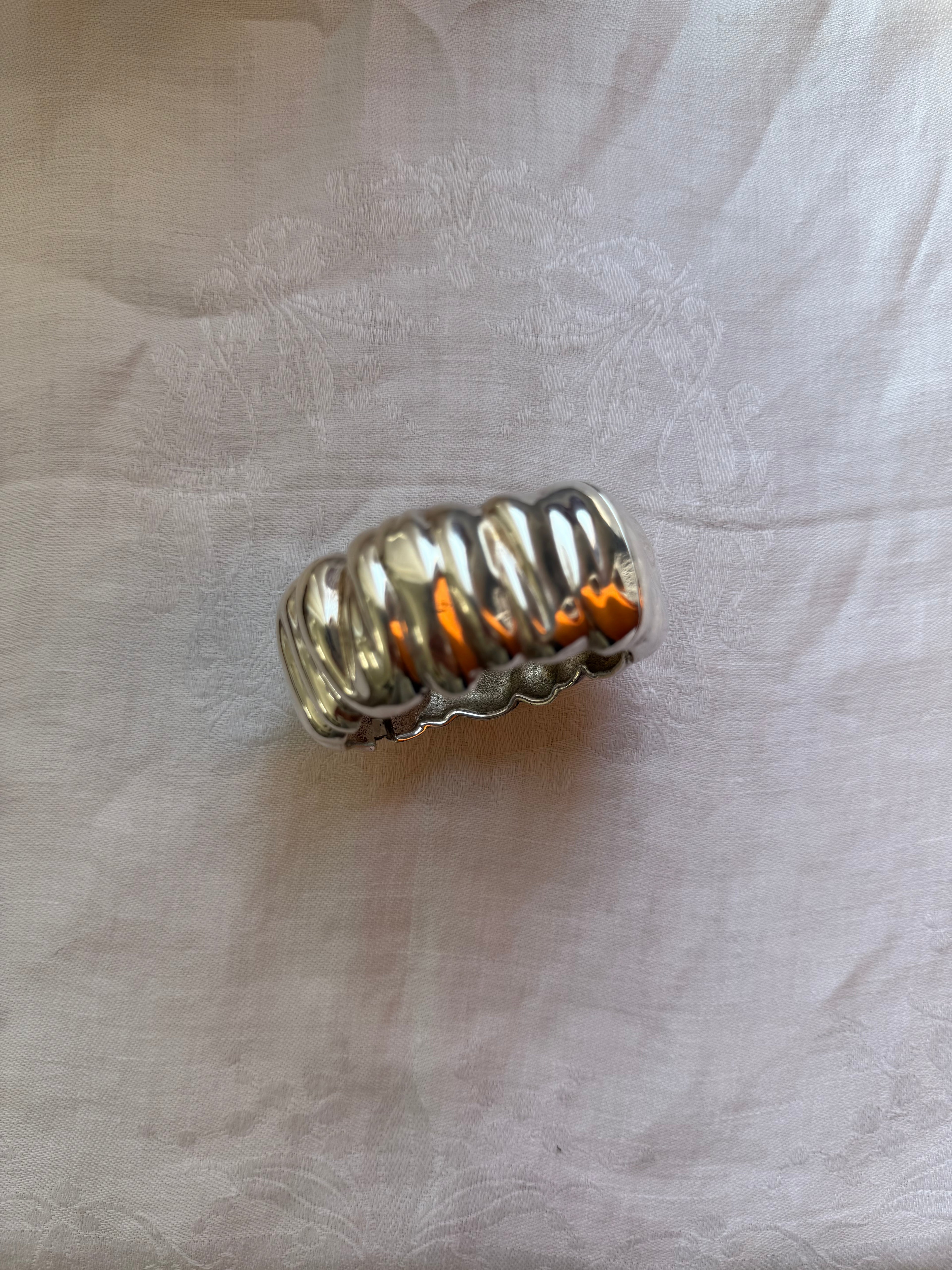 Metallic cylindrical object on a textured white surface