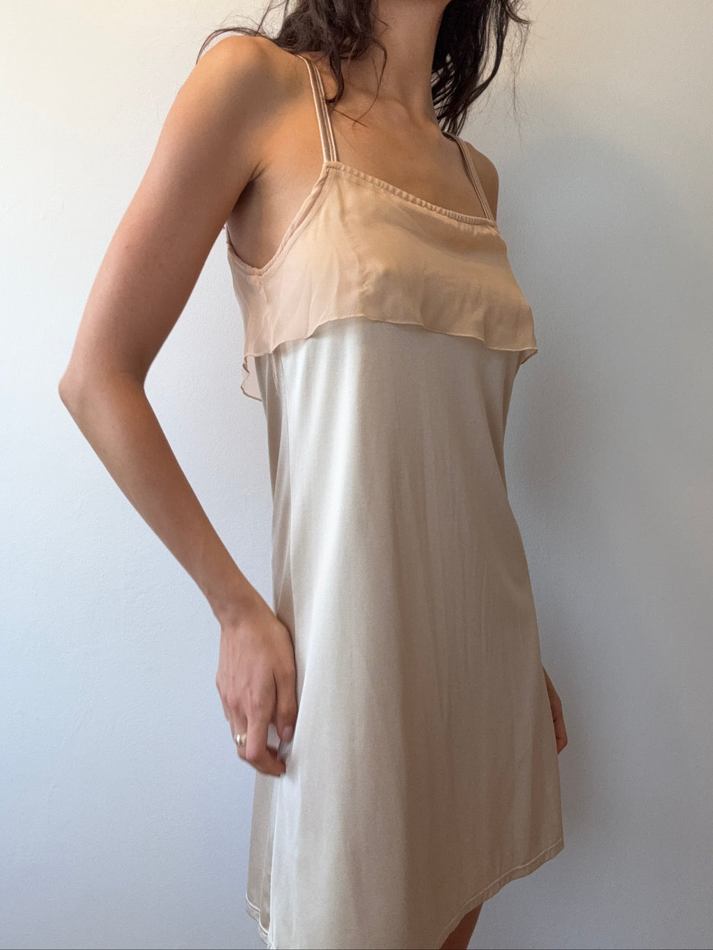 Woman wearing a beige dress against a plain background