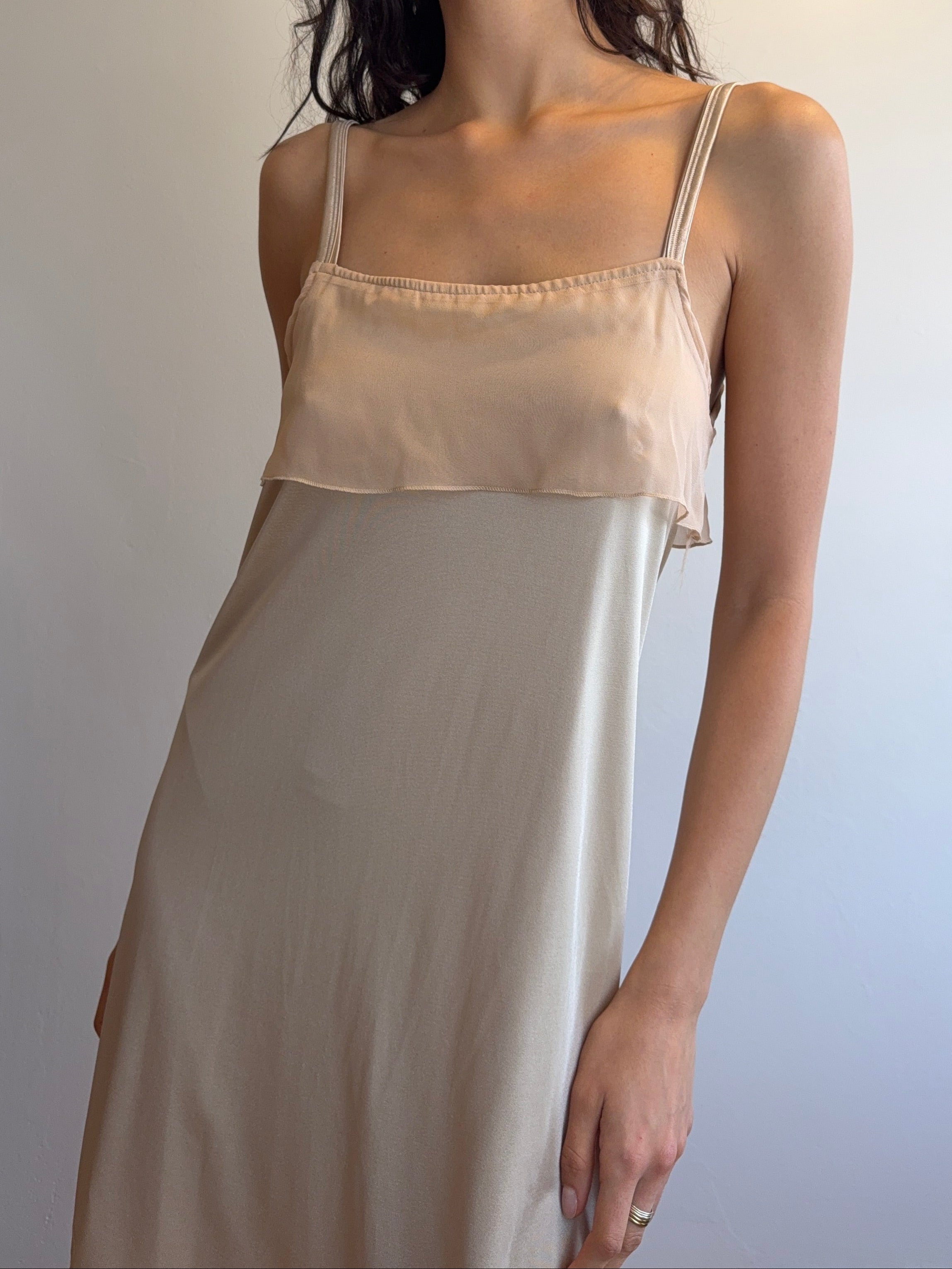 Woman wearing a beige dress against a plain background