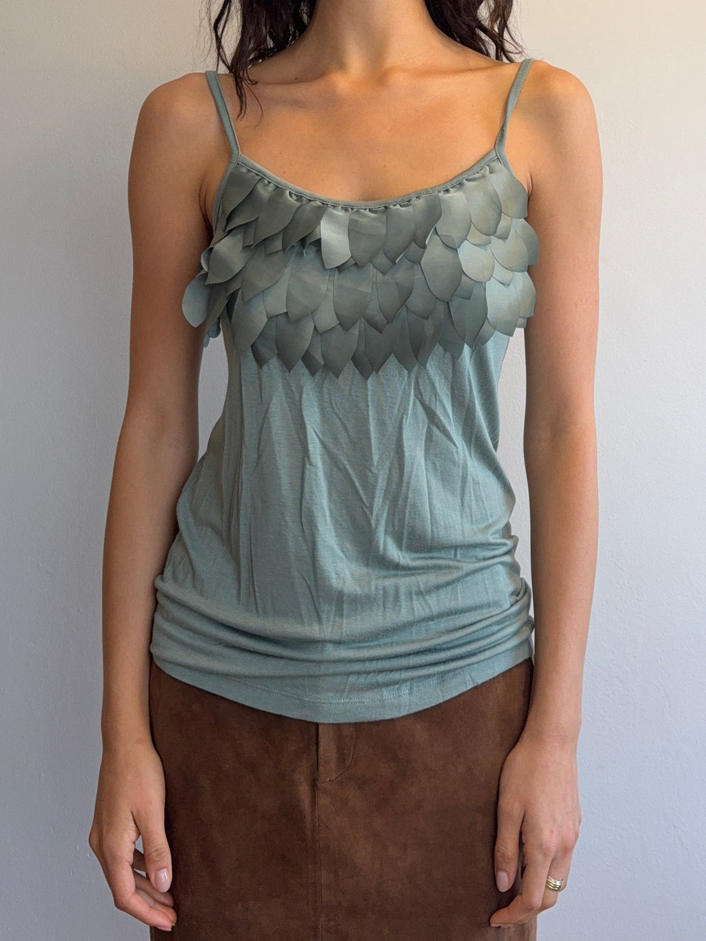 Woman wearing a light blue dress with floral details on a plain background