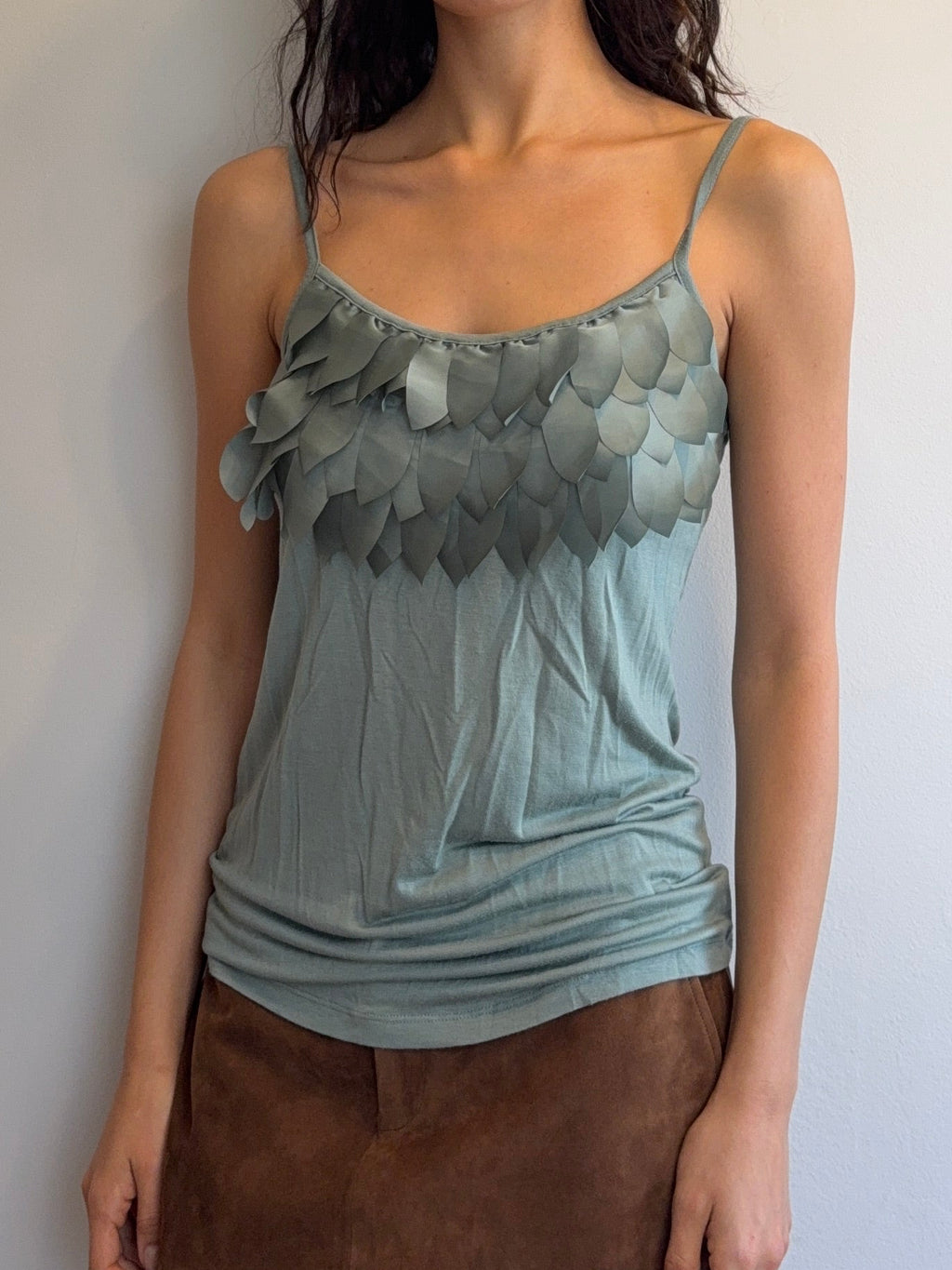 Woman wearing a light blue top and brown skirt lying on a white floor.