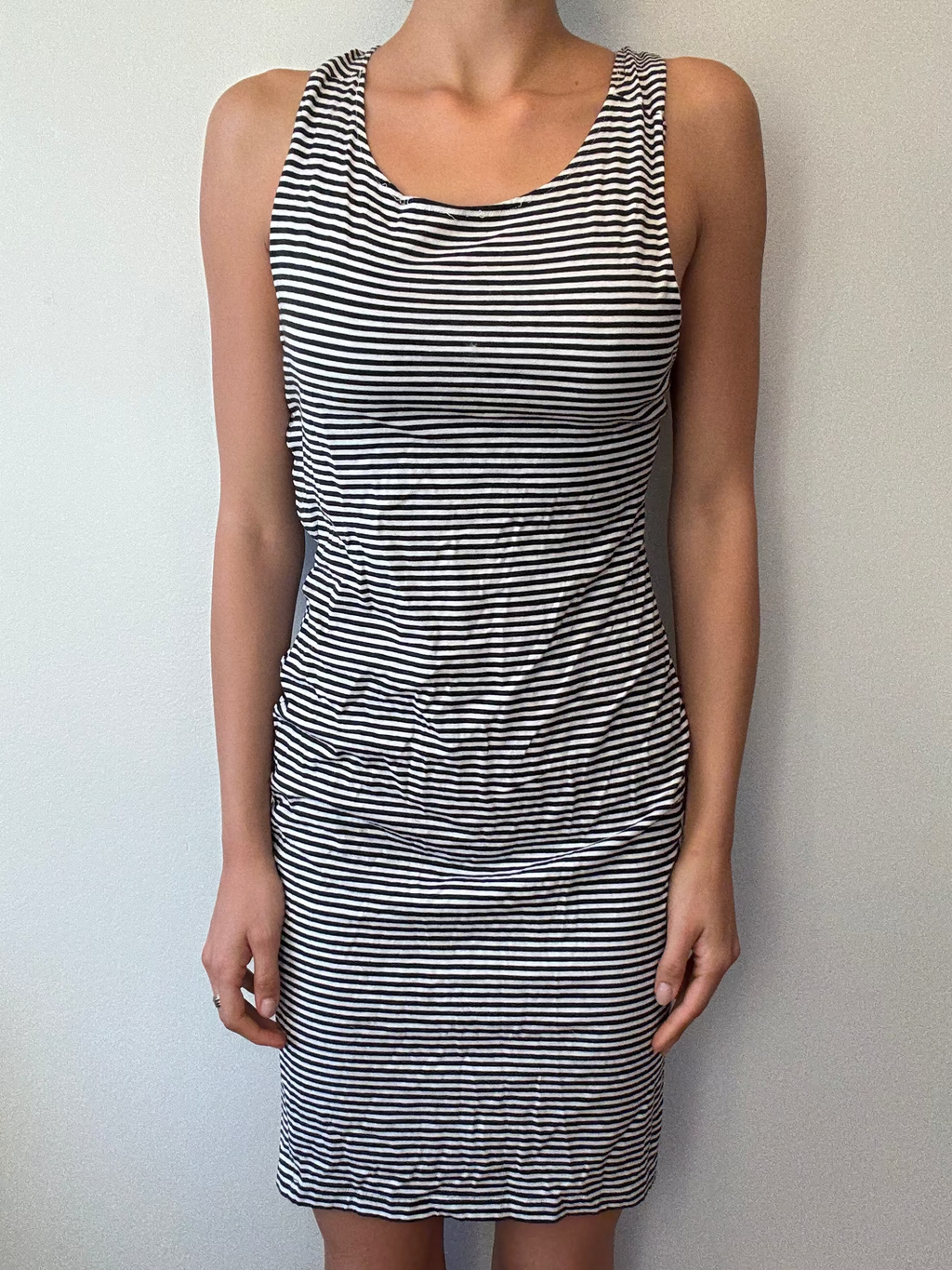 Person wearing a black and white striped dress against a plain background