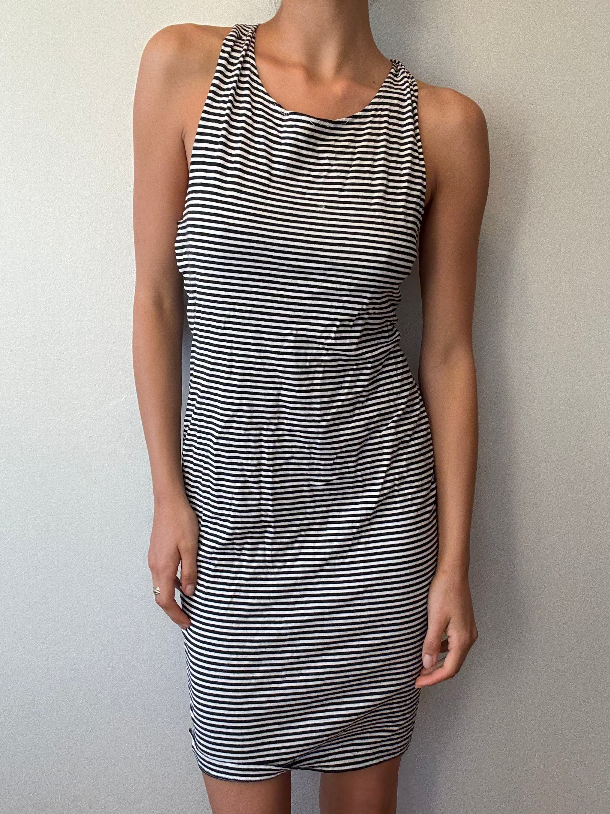 Woman wearing a black and white striped dress against a plain background