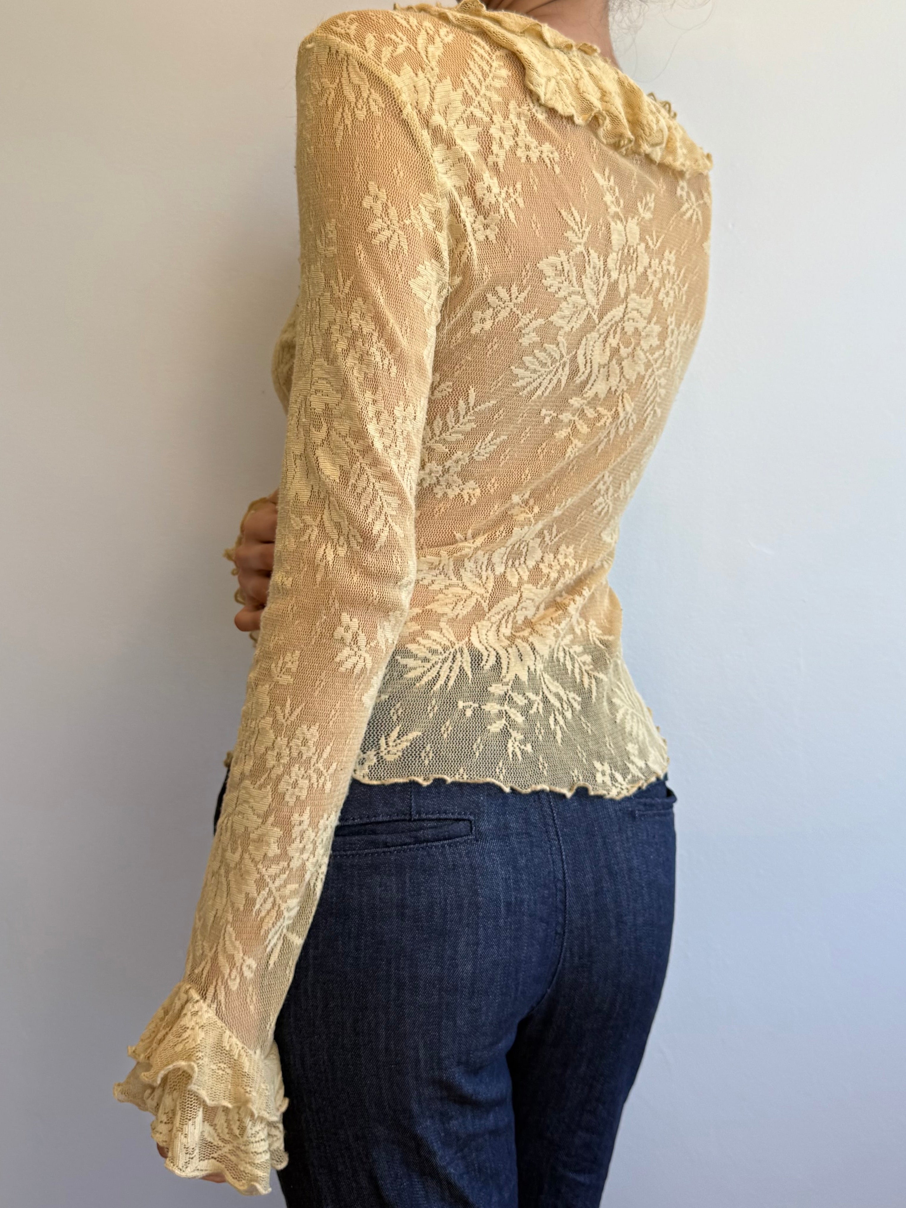 Beige lace top worn by a person against a plain background