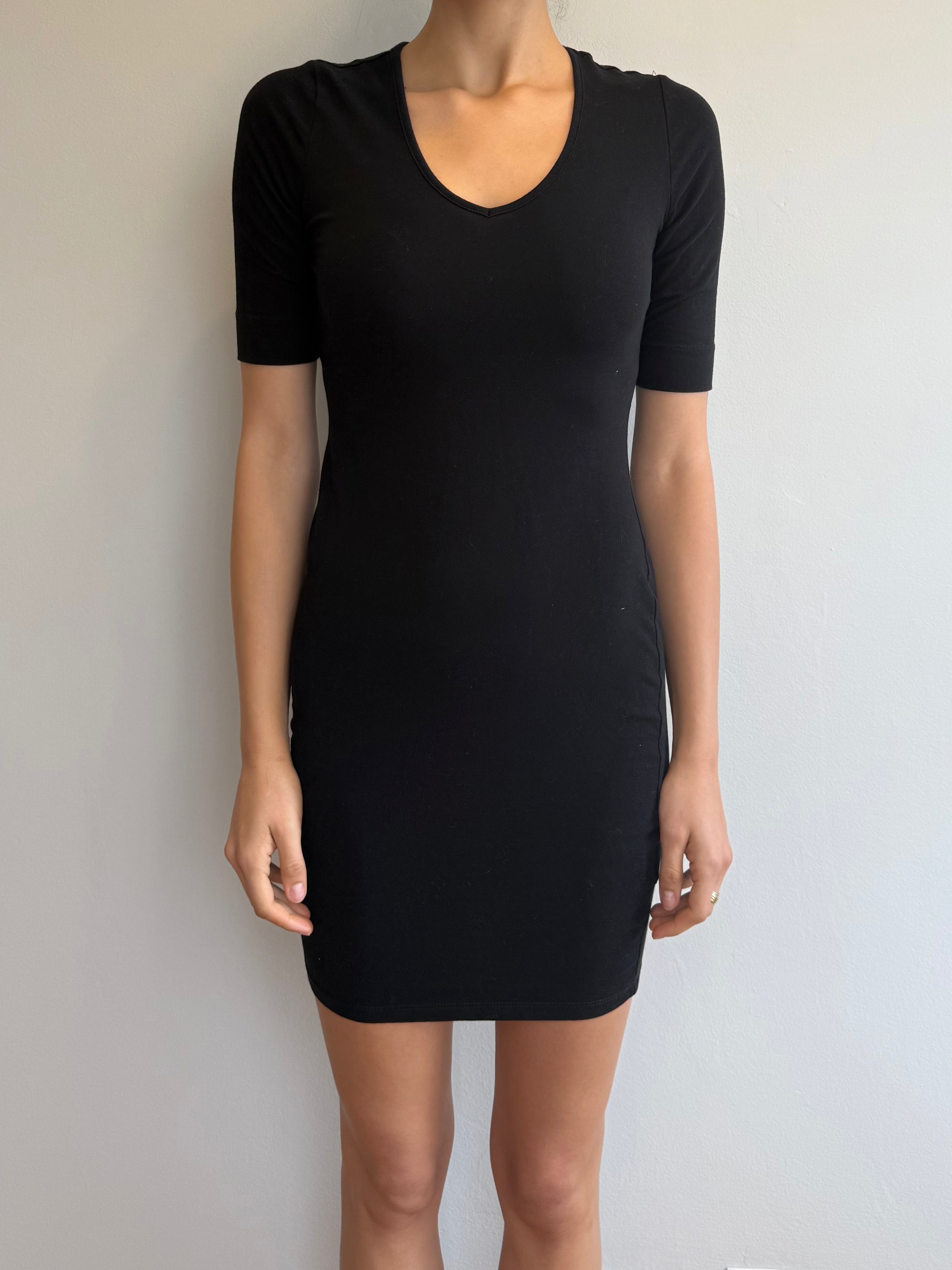 Black dress worn by a person against a plain background