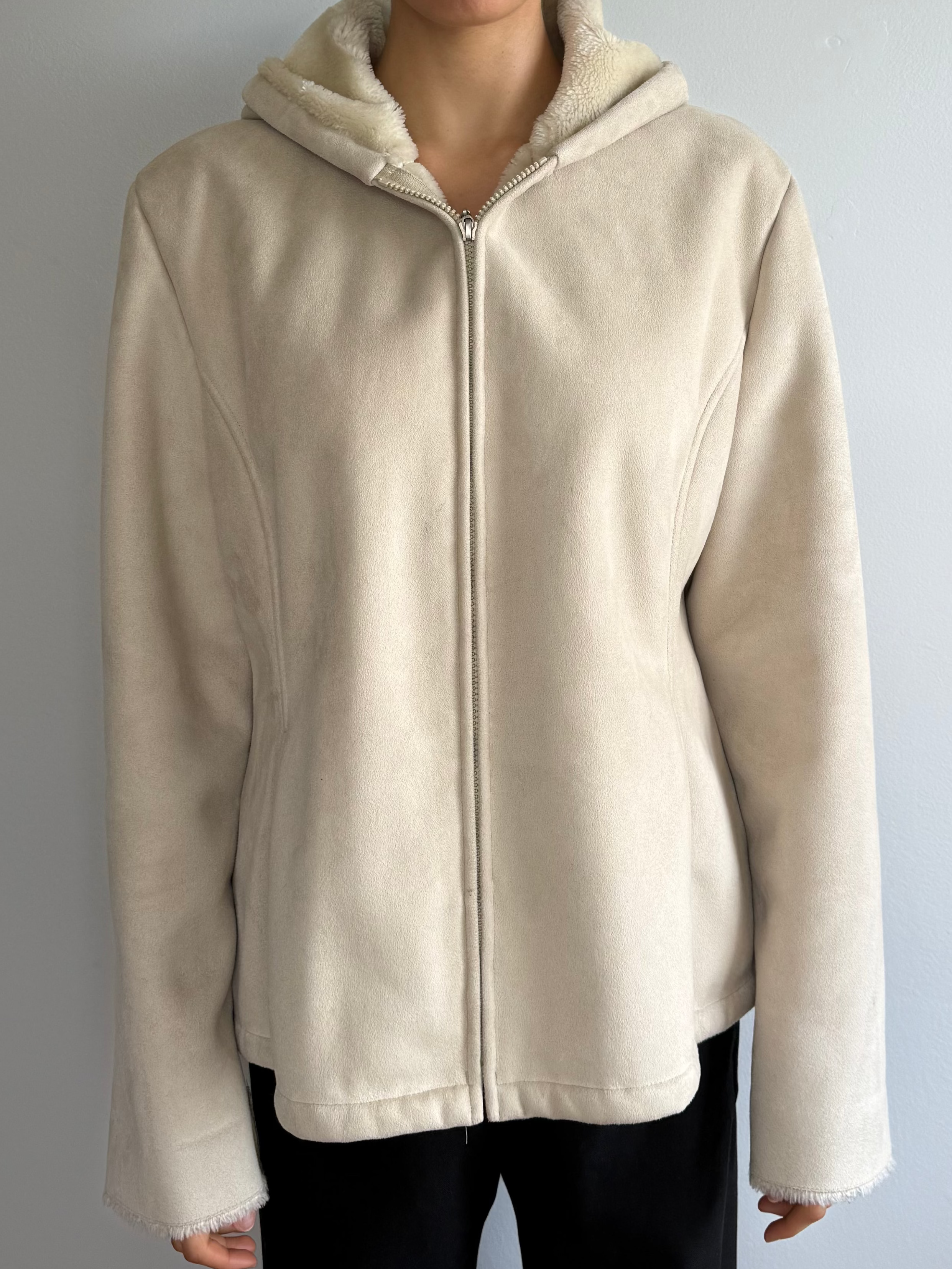 Person wearing a beige hoodie against a plain background