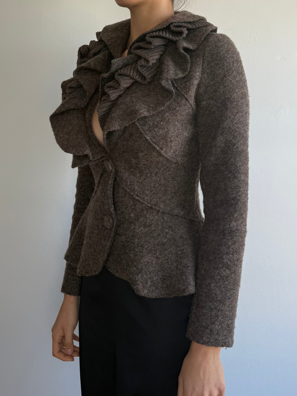 Woman wearing a brown textured jacket against a plain background